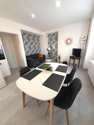 une table blanche et des chaises dans un salon dans l'établissement Élégant appartement Vatan centre, à Vatan