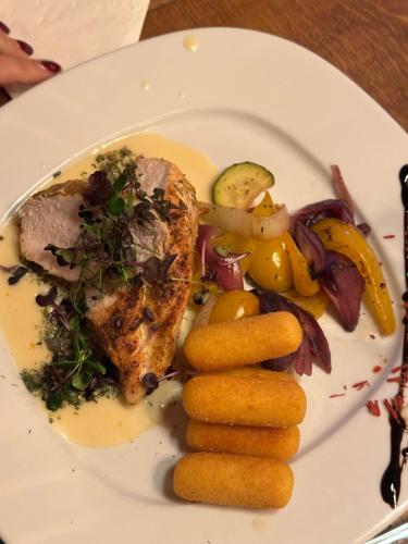 a plate of food with meat and vegetables on it at Apartments Schrim in Fiegler