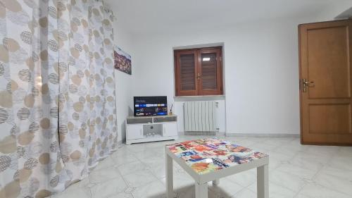 a table in a room with a curtain and a television at Casa in Piazza in Cinquefrondi