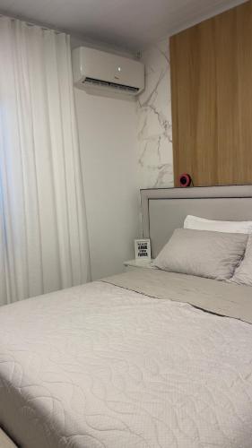 Rio ForcaçãoにあるSuite no centro de Doutor Pedrinhoの白いベッドと窓のある寝室