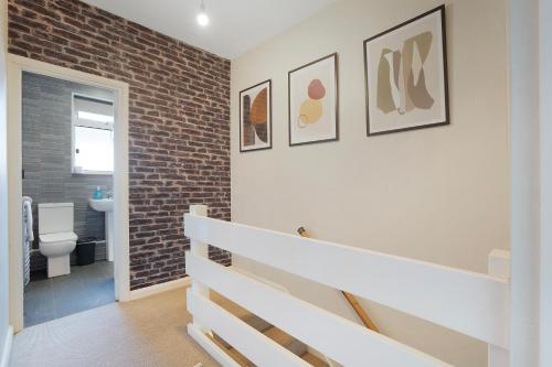 ein Badezimmer mit Toilette und einer Ziegelwand in der Unterkunft High-End home, Free Parking, 3 beds, sleeps 5 in Ferryhill