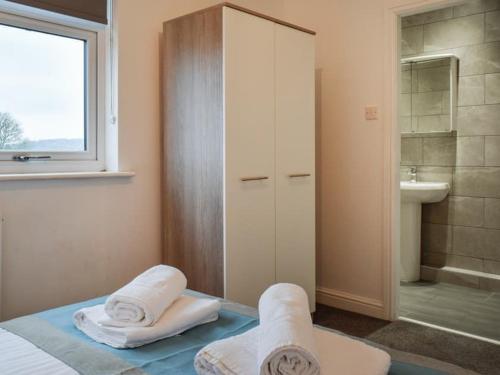a bathroom with a bed and a shower and a sink at St John's Newsome Serviced Apartments in Huddersfield