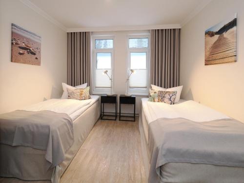 zwei Betten in einem Zimmer mit zwei Fenstern in der Unterkunft Seehof Seehof 121 in Bansin