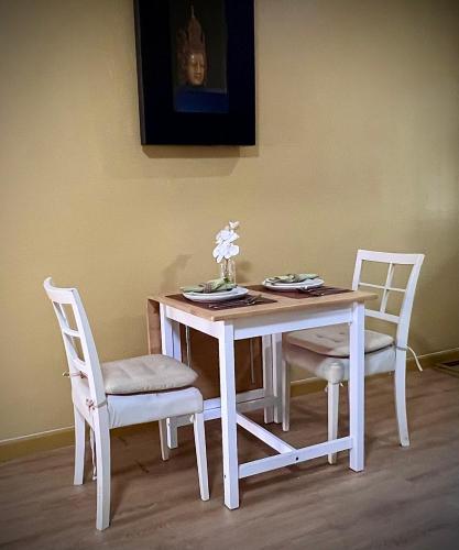 a white table with two chairs and a white table and chairsktop at Casa Gris with Shared Pool in Ban Bo Han