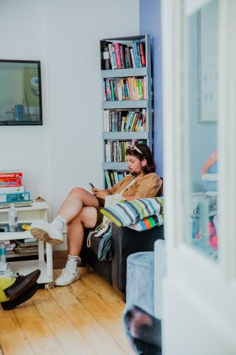 a woman sitting on a chair in a living room at Astor Museum Hostel in London