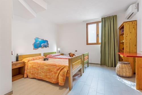 a bedroom with a bed with a dog laying on it at Villino Elisa in Tertenìa