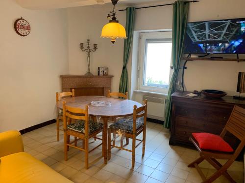 une salle à manger avec une table et des chaises et une fenêtre dans l'établissement maison le croixsud, à Peyriac-de-Mer