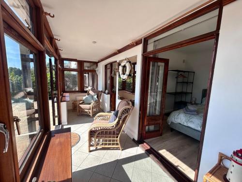 a room with a balcony with a bed and glass doors at Your Lake side Retreat Sleeps 10-12 Nr Park & Sea in Poole