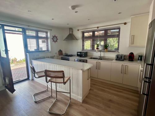 a kitchen with a counter and a chair in it at Your Lake side Retreat Sleeps 10-12 Nr Park & Sea in Poole