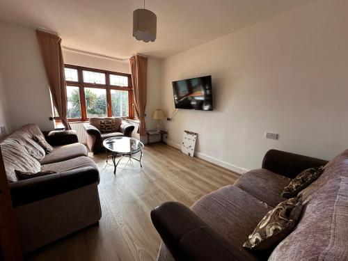 a living room with a couch and a table at Your Lake side Retreat Sleeps 10-12 Nr Park & Sea in Poole