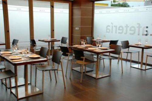 a conference room with tables and chairs and a screen at Sercotel Aura Algeciras in Algeciras