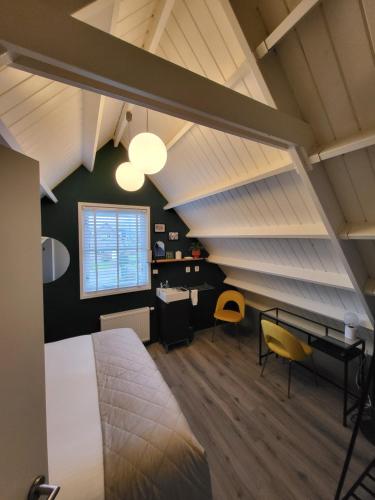 una camera da letto con un letto, una scrivania e una finestra di Je B&B Giethoorn, incl fietsen! a Giethoorn
