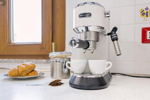 a mixer on a counter with two cups of coffee at Villino Elisa in Tertenìa