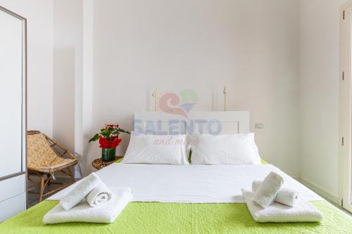 a bedroom with a large white bed with towels on it at Salentoandmore - Casa Nova in Torre Pali 