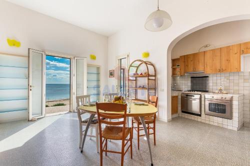 a kitchen with a table and chairs and the ocean at Salentoandmore - Casa Nova in Torre Pali 