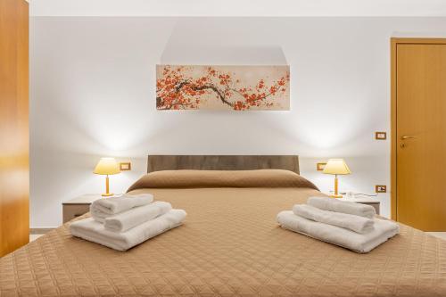 a bedroom with a bed with two white towels at Villino Elisa in Tertenìa