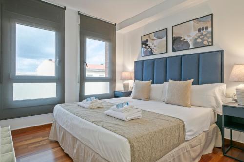 a bedroom with a large bed with two towels on it at Alcam Mallola in Esplugues de Llobregat