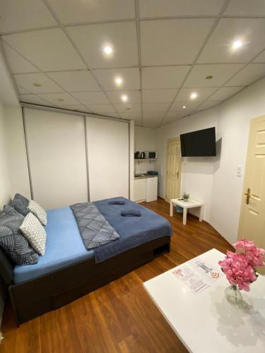 a bedroom with a bed and a table with flowers at Malasits Apartman in Győr