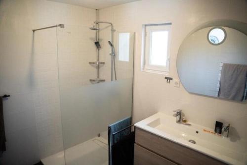 une salle de bain avec une douche, un lavabo et un miroir dans l'établissement Ti Marie Thérèse, à Fouesnant