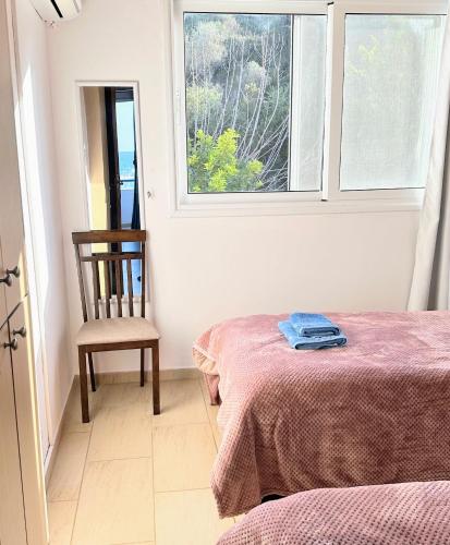 a room with a bed and a chair and a window at Seafront Escape in Latchi in Polis Chrysochous