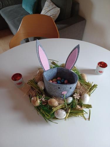 a basket of easter eggs and rabbits on a table at Au Vieux Lavoir in Alle