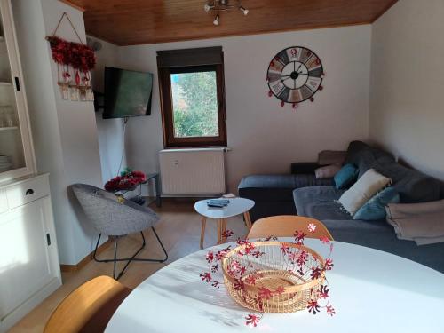 a living room with a table and a couch at Au Vieux Lavoir in Alle