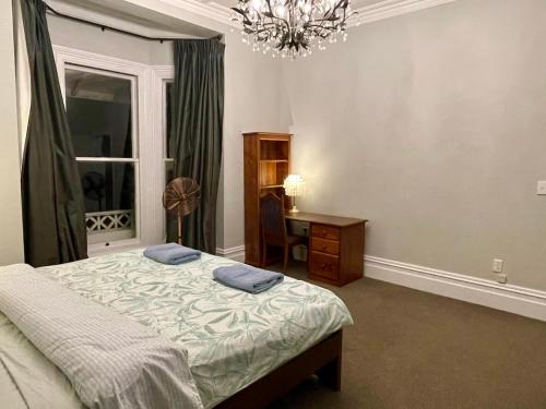 a bedroom with a bed and a desk and a window at Winter Fun - Spa, Pinball, Billiard and more in Kumeu