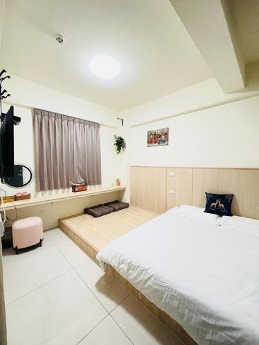 a bedroom with a large bed and a television at 柴鹿森苑 鹿港 in Lukang