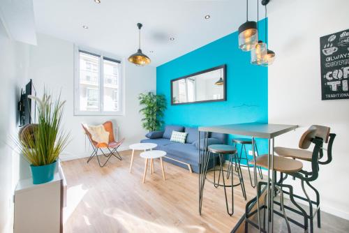 un salon avec un mur bleu et une table avec des chaises dans l'établissement SV - Au Pied du Vieux Port, à Marseille