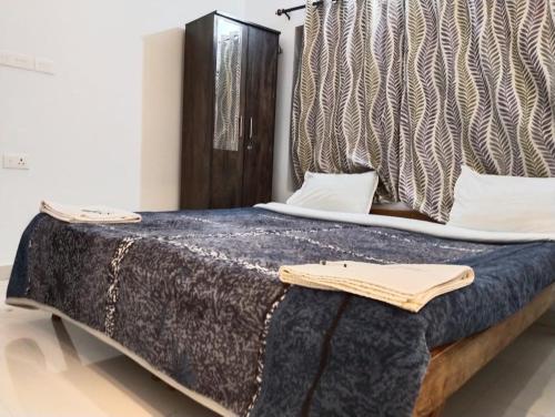 a bedroom with a large bed with a blanket at Fortune Retreats in Ooty