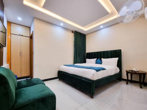 a bedroom with a bed and a green couch at Hotel Summer Palace Murree in Murree
