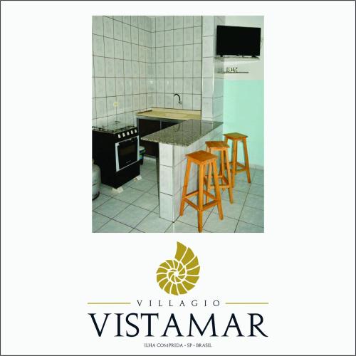 a kitchen with a counter and stools in it at Villagio Vistamar Ilha Comprida in Ilha Comprida