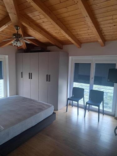 a bedroom with a bed and two chairs in it at B&B " Guzzi - Inn " in Mandello del Lario