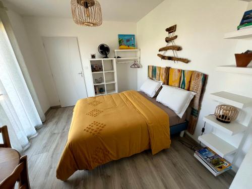 sypialnia z łóżkiem z żółtym kocem w obiekcie La chambre de Séraphine w mieście Biscarrosse
