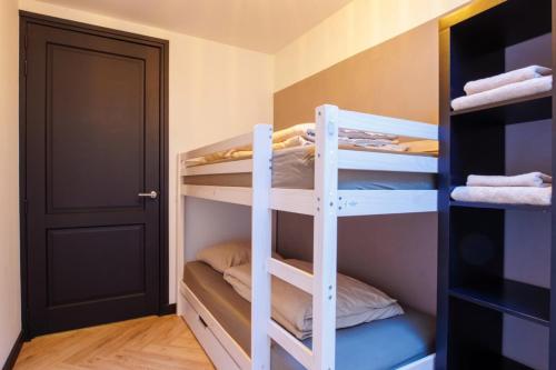 a bunk bed room with bunk beds and a door at In de Mid - Prachtige appartementen in hartje Joure in Joure