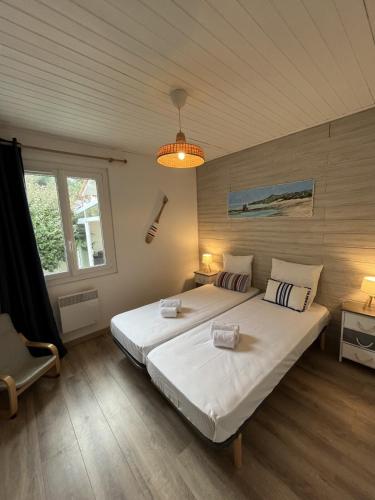 une chambre avec un grand lit blanc et une fenêtre dans l'établissement Maison paisible à 100m de la Mer, à Bretignolles-sur-Mer