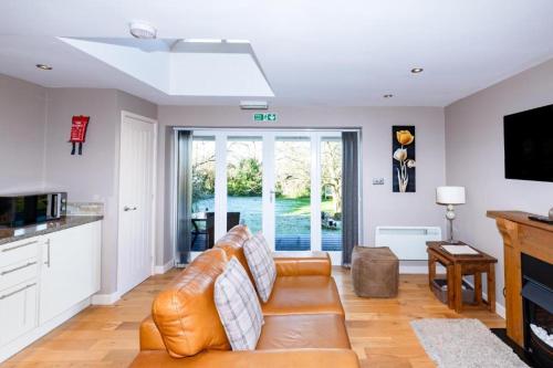 a living room with a leather couch and a kitchen at Beaconsfield Farm in Wells