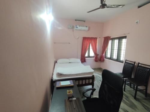 a small room with a bed and a table and chairs at Katadi beach homestay in Trichūr