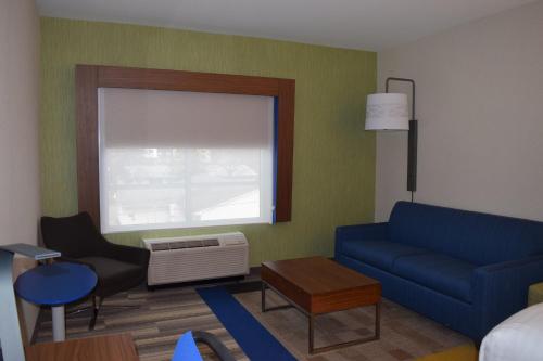 a living room with a blue couch and a window at Holiday Inn Express & Suites Ithaca by IHG in Ithaca