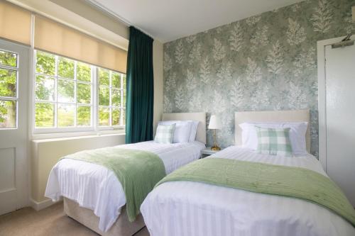 two beds in a bedroom with green and white at Whatton Cottage in Gullane