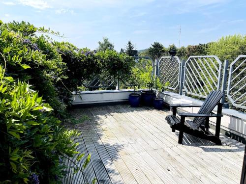 una terraza de madera con un banco y algunas plantas en Charming 1930s Home, en Kleve