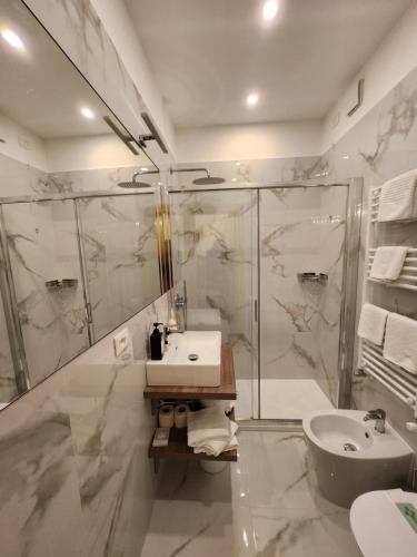 a white bathroom with a sink and a shower at Hotel Villa Edera in Venice-Lido