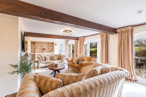 a living room with couches and a table at Moonzie Mill House in Balmullo