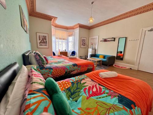 a room with two beds and a couch at Apart Bernard Rooms in Edinburgh
