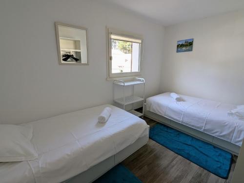 une petite chambre avec deux lits et une fenêtre dans l'établissement Maison dans résidence avec piscine et tennis - 4 personnes, à Pornic