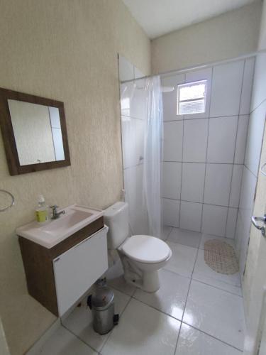 a bathroom with a white toilet and a sink at Praia do Paraíso in Mosqueiro