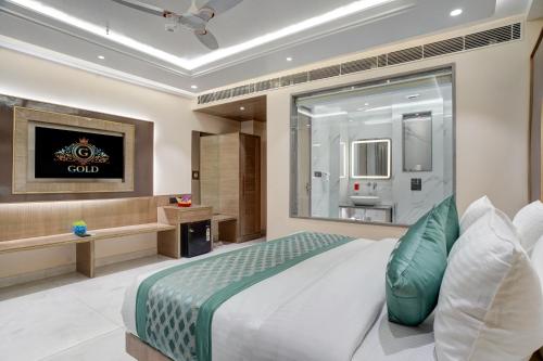 a bedroom with a large bed and a bathroom at Gold The Prime Newly Built 2 Mins From Connaught Place and Railway Station in New Delhi