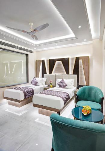 a bedroom with two beds and a table and chairs at Gold The Prime Newly Built 2 Mins From Connaught Place and Railway Station in New Delhi
