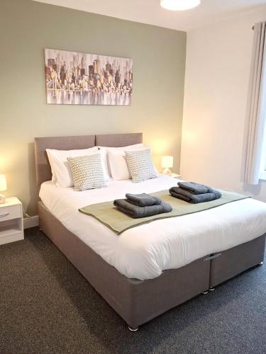 a large bed in a bedroom with two pillows on it at Modern Bright 3 Bedroom House in Lincolnshire