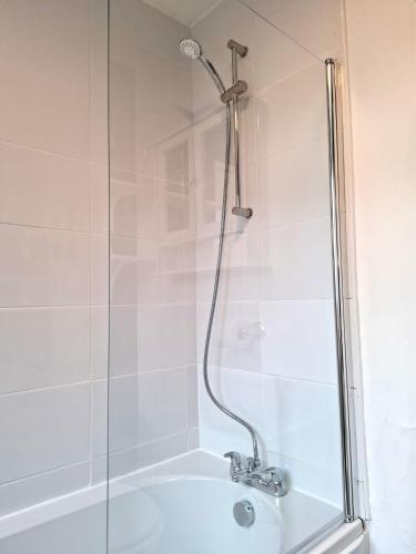 a shower with a glass door next to a tub at Modern Bright 3 Bedroom House in Lincolnshire